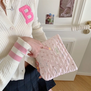 Quilted pink makeup bag with cute bear patterns held by a model in a cozy setting