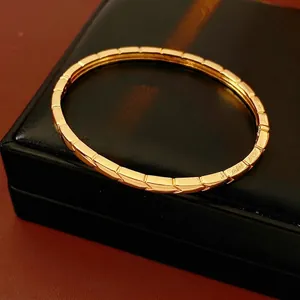 Luxury 18K gold plated arrow pattern bangle displayed on black leather box