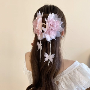 Detail of mesh flower hair claw clip with crystal tassel and butterfly pendant on model