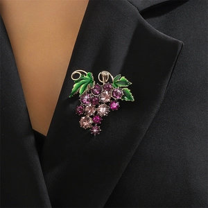 Sparkling purple grape brooch with crystal stones and green enamel leaves on suit lapel