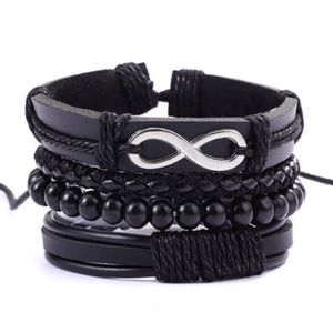 Détail de bracelets en cuir noir empilés avec corde tressée et breloque infini argentée