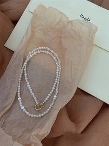 Detail shot of irregular baroque freshwater pearl necklace with golden OT clasp closure