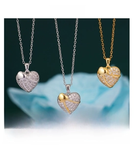Detailed view of three heart pendants in silver, gold, and two-tone with pave cubic zirconia