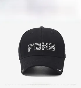 Close-up of FBXS embroidered logo on black cotton twill baseball cap with white curved trim
