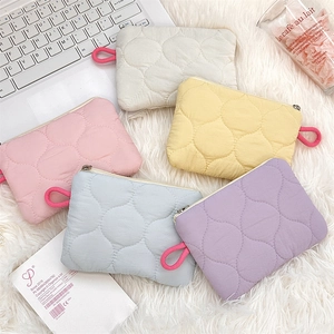 Detailed set of five quilted cosmetic pouches in cream pink yellow blue and purple