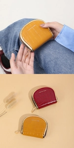 Detail of semi-circular PU leather wallets with glossy crocodile pattern and gold zipper