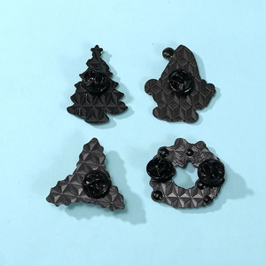 Back view of four Christmas enamel pins showing metal texture and butterfly clutch pins