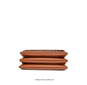 Detailed view of brown soft leather crossbody bag with pleated texture and silver rivets