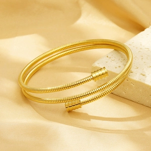 Detail shot of golden 18k plated double-layer spiral cable spring cuff bracelet