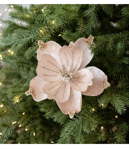 Close-up of velvet Christmas flower with gold glitter and pearl center on tree