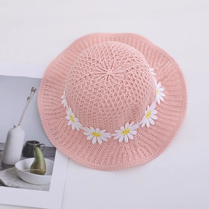 Pink woven straw sun hat for girls with white daisy embroidery on clean white background