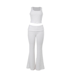 Women's two-piece white textured knit set featuring a sleeveless top and flared trousers