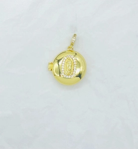 Detail of a golden round locket pendant with a Virgin Mary relief and small diamonds