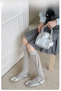 Close-up of gray knit calf socks featuring a delicate ribbon bow in balletcore style
