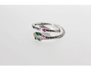 Close-up of silver snake ring with green stone eyes and red and white zircon accents