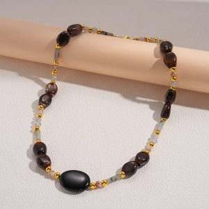 Detailed view of bohemian acrylic stone beads and golden spacers on a long necklace