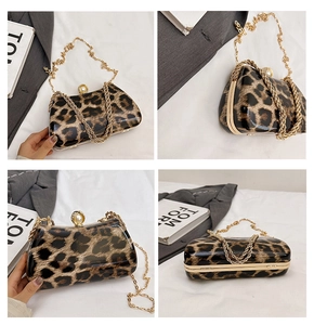 Detail view of leopard print clutch bag featuring a gold chain and large pearl clasp