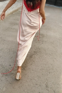 Detail of satin long dress with lace trim and slim straps shown from a back walking view