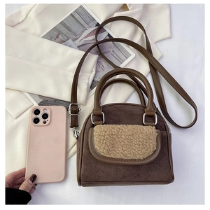 Detail view of mini plush handbag with brown suede and khaki faux fur pocket