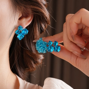 Close-up of royal blue glass bead flower earrings in a geometric cube cluster design