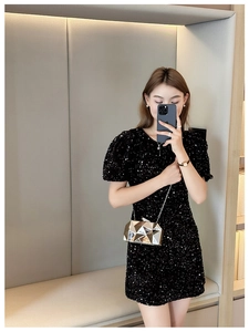 Golden geometric evening clutch bag paired with a black sequin dress in a mirror selfie