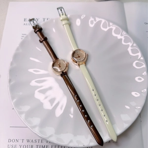 Detail of elegant ladies' small dial quartz watches with slim leather straps on white tray