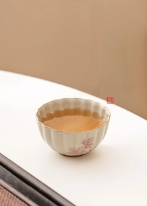 Detailed view of daisy ceramic tea cup with hand-painted floral art and flower petal rim