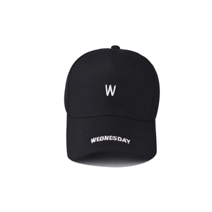 Détail de la broderie blanche lettre W et texte Wednesday sur une casquette en coton noir