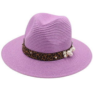 Detail of purple woven Panama hat featuring leopard print band with pearls and white flowers