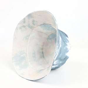Detail showing the gray-blue tie-dye fabric and reinforced stitching on a reversible bucket hat