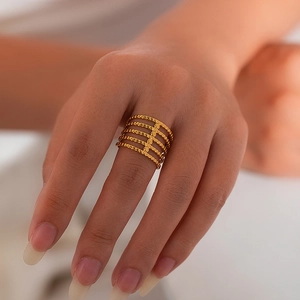 Detail of layered gold titanium steel ring featuring parallel beaded bands for women
