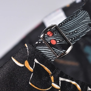 Macro detail of adjustable metal buckle and patterned strap on a black baseball cap