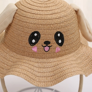 Detailed close-up of the woven straw material and cute embroidered animal face on hat