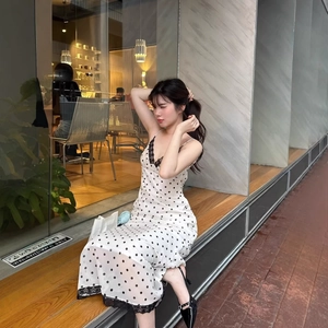 Vintage white polka dot maxi dress with black lace trim and spaghetti straps in street style