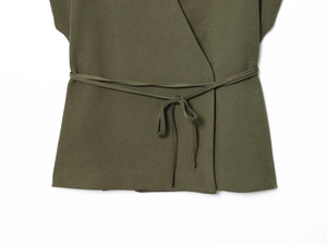 Detail of olive green wrap top showing waist tie and fine twill fabric texture