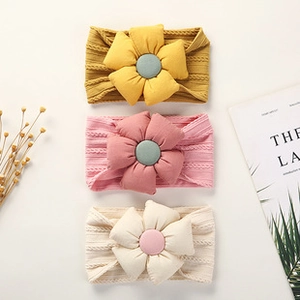 Three-piece set of elastic infant headbands with large fabric flowers in soft autumn colors