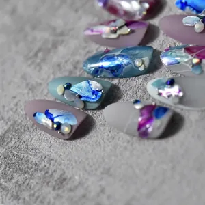 Artistic handmade press-on nails with marble texture and premium shell stone accents