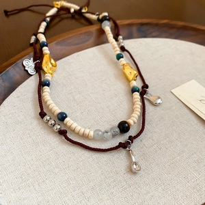 Detail of coffee bean acrylic beads and braided rope on bohemian style jewelry set