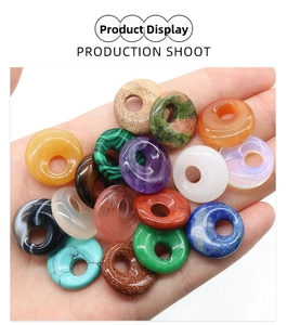 Macro shot of assorted natural crystal stone donuts held in hand showing polished texture