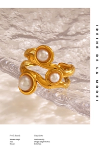 Detailed view of gold irregular organic ring with three white pearls on glass