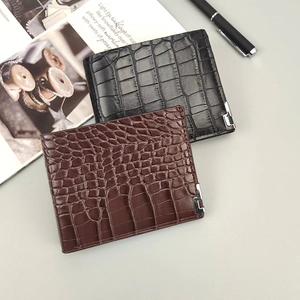 Close-up of black and brown crocodile textured wallets with silver metal corner accents