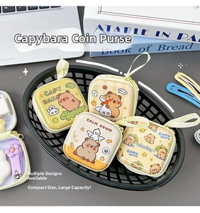 Mini portamonete Capybara in latta in un cesto nero su una scrivania da ufficio