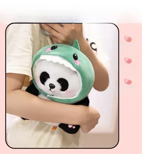 Detail of soft plush panda wearing a green shark costume held by a person