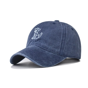 Macro detail of cartoon dog embroidery on navy washed cotton baseball cap