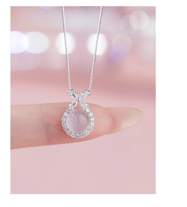 Macro shot of S925 silver necklace with butterfly detail and pink chalcedony pendant