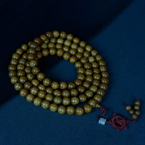 Bracelet bouddhiste en bois de Palo Santo 108 perles sur fond bleu foncé