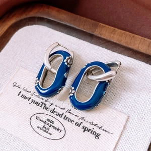 Détails des boucles d'oreilles vintage en émail bleu avec des motifs floraux argentés