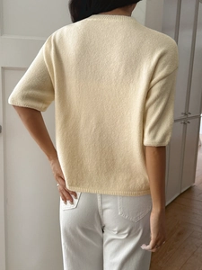 Back view detail of beige short sleeve knit top with clear texture and casual fit