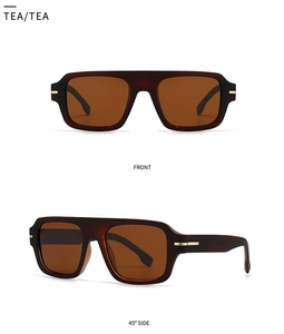 Detail view of square oversized tea-colored sunglasses with gold metal hinge accents