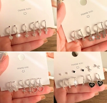 Detail view of 9-piece earring set with butterfly, star, and cross charms on display card